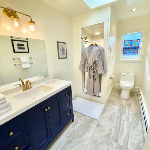 a bathroom with a sink and a toilet and a mirror at Otter's Pond Bed and Breakfast in Eastsound