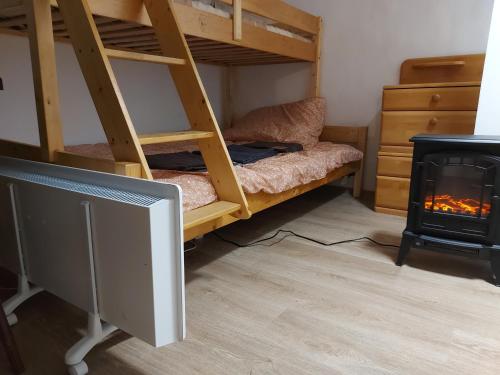a room with a bunk bed with a fireplace at Zsindely Ház Károlyfalva Sátoraljaújhely in Sátoraljaújhely