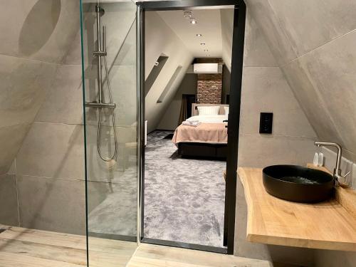 a bathroom with a shower and a sink and a bedroom at Hotel de Prince in Nijmegen
