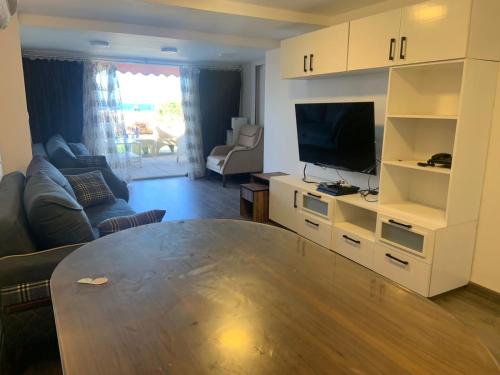 a living room with a table and a television at JERMA apartments شاليه المعموره in Alexandria