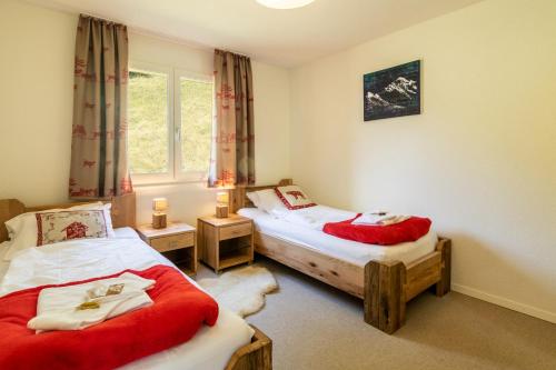 a bedroom with two twin beds and a window at Chalet Hannegg Penthouse in Wengen