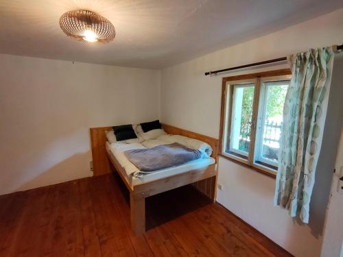 ein kleines Schlafzimmer mit einem Bett und einem Fenster in der Unterkunft Gemütliche Ferienwohnung mit Kamin und Garten in Garmisch-Partenkirchen