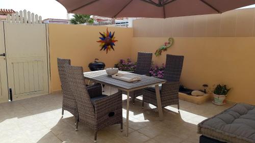 コスタ・カルマにあるLa Cabaña - Fuerteventuraのダイニングルーム(テーブル、椅子、パラソル付)