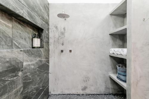 a bathroom with a walk in shower next to a wall at CASA EN EL CENTRO & CORAZON DE CANCUN in Cancún