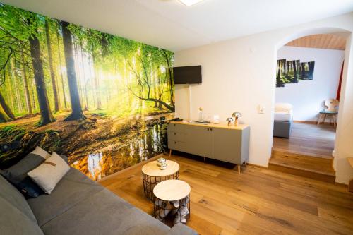 a living room with a wall mural of a forest at Hotel Tannenmühle in Grafenhausen