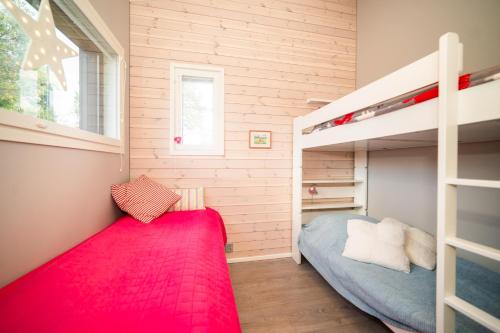 um pequeno quarto com um beliche e um tapete vermelho em Lomamökki, loistava sijainti em Syöte