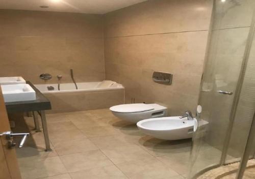 a bathroom with a toilet and a sink and a tub at SEA AIR OCEAN VILLAGE in Gibraltar