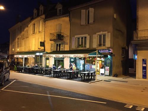 un restaurante con mesas y sillas en una calle por la noche en SUPERBE TRIPLEX MEUBLÉ TOUT CONFORT HYPER CENTRE ST CÉRÉ 3 CHAMBRES WIFI 120 M2 8 pers max, en Saint-Céré