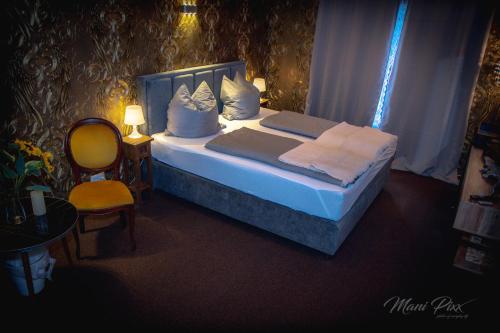 a bedroom with a bed with pillows and a chair at Villa Prestige in Zeitz