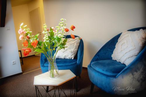 a vase of flowers on a table next to a blue couch at Villa Prestige in Zeitz