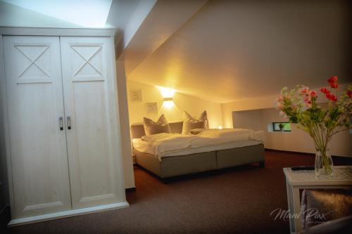 a bedroom with a bed and a vase of flowers at Villa Prestige in Zeitz