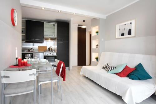 uma sala de estar com um sofá branco e uma mesa em Apartament Słoneczny em Gdynia