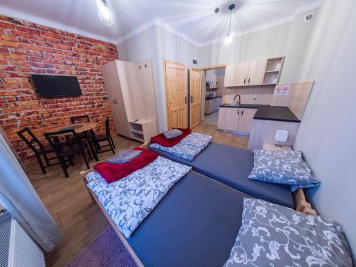 a living room with two beds and a kitchen at Apartamenty Rycerskie in Inowłódz