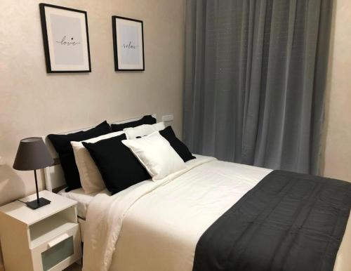 una camera da letto con un letto con cuscini bianchi e neri di Good appartement near at the aeroport a Nouaseur