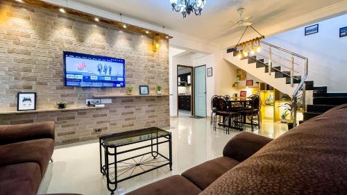 a living room with a tv on a brick wall at Beach Retreat Villa in Varca