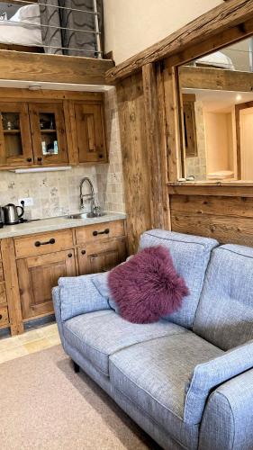 - un canapé avec un oreiller violet dans la cuisine dans l'établissement Oree Studio Mezzanine, à Megève