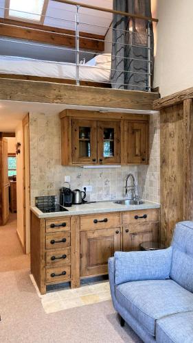 une cuisine avec un évier et un canapé dans une chambre dans l'établissement Oree Studio Mezzanine, à Megève