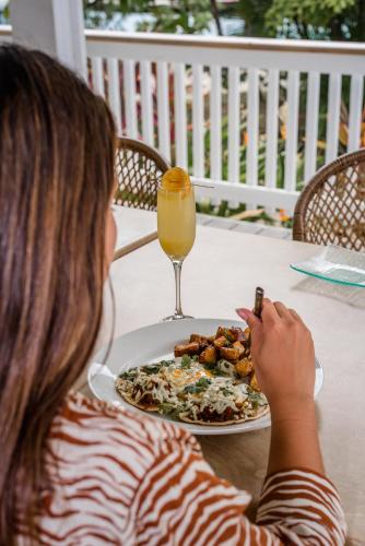a woman sitting at a table with a plate of food at Barefoot Cay Resort in Roatan
