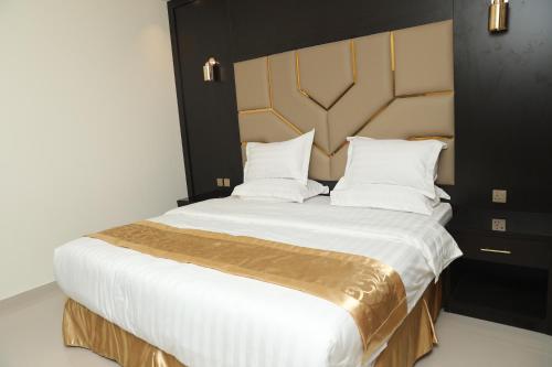 a bedroom with a large bed with white sheets and pillows at السامية الفندقية in Sharurah