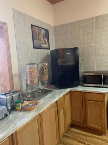 eine Küche mit einer Arbeitsplatte mit einer Mikrowelle und einer Theke sidx sidx in der Unterkunft Zion's Most Wanted Hotel in Hildale