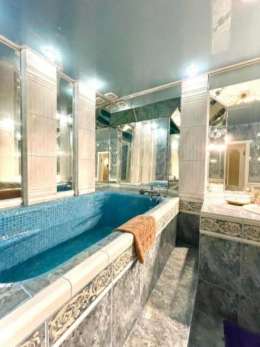 uma grande casa de banho com uma banheira e um espelho grande em Great one Bed right near Opera House em Kiev