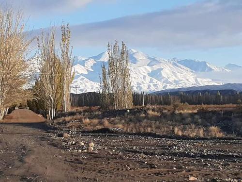 a dirt road in front of a snow covered mountain at Lodge Atamisque in San José