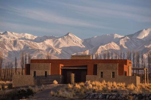 a building in the middle of a desert with mountains at Lodge Atamisque in San José
