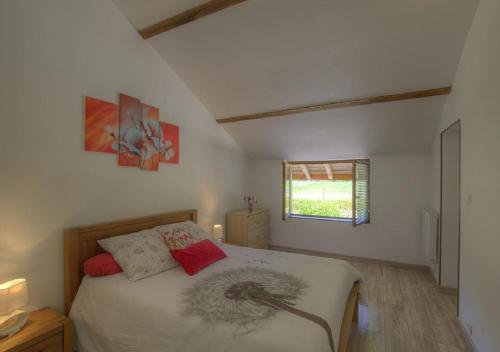 1 dormitorio con cama y ventana en le paradis vert en Pirajoux