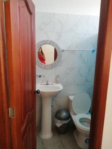 uma casa de banho com um lavatório, um WC e um espelho. em Suite de lujo totalmente independiente em Machala