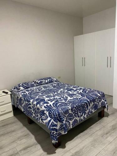 1 dormitorio con 1 cama y armarios azules y blancos en Suite de lujo totalmente independiente, en Machala