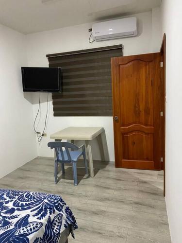 una camera con un letto, un tavolo e una porta di Suite de lujo totalmente independiente a Machala