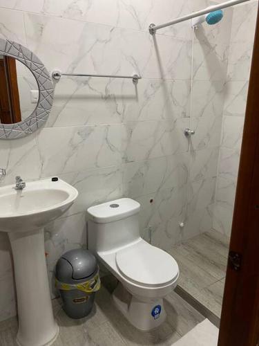 Baño blanco con aseo y lavamanos en Suite de lujo totalmente independiente, en Machala