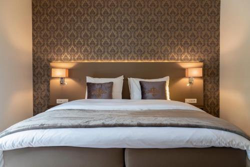 a bedroom with a large bed with two pillows at KerkHotel Biervliet in Biervliet