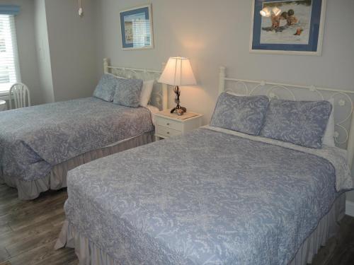 a bedroom with two beds and a lamp on a night stand at Studio Style Home 308L features Golf in Calabash