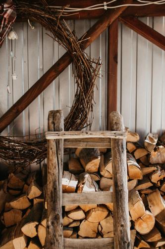 a wooden bench sitting next to a pile of wood at Málna Major in Mályinka