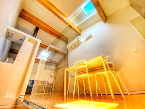 a dining room with yellow chairs and a table at Apartamento Zocailla in Gata