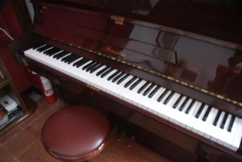 an old piano with a stool next to it at Vigna dell'Agrifoglio - Bed and Breakfast in Velletri
