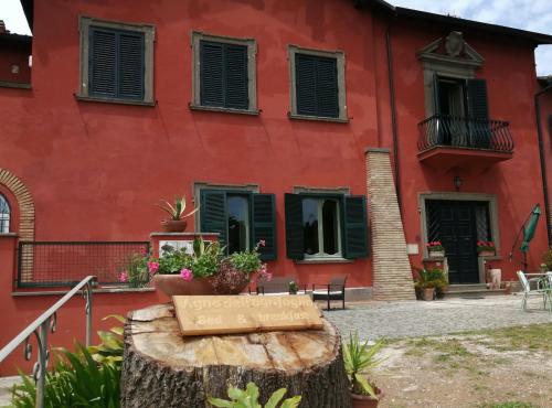 a red building with a sign on a tree stump at Vigna dell'Agrifoglio - Bed and Breakfast in Velletri