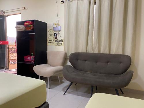 sala de estar con silla y cama en Suites Flor de Lis, en Pirenópolis
