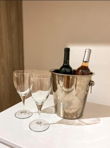 two wine glasses and a bucket of wine bottles at Nosso Recanto Pérola in Capitólio