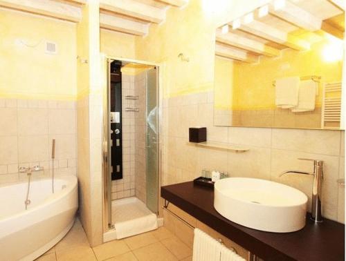 La salle de bains est pourvue d'un lavabo, d'une douche et d'une baignoire. dans l'établissement Villa Morneto, à Vignale