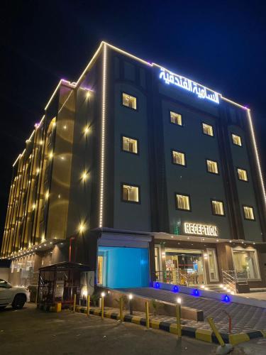 a hotel building with a sign on it at night at شقق السامية للشقق المخدومة in Sharurah
