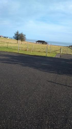 an empty road with a fence on the side of a field at No 7 in Back