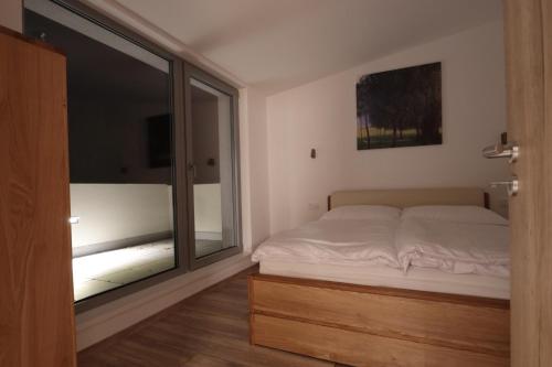um quarto com uma cama e uma grande janela em Střešní apartmán s terasou em Hradec Králové