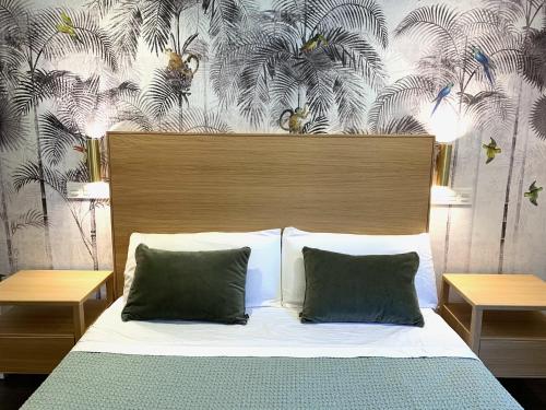 1 cama con 2 almohadas y papel pintado con motivos florales en Emérita Luxury Home, en Burgos
