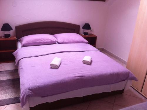 1 dormitorio con 1 cama morada y 2 toallas en Guesthouse Magdalena, en Rakovica