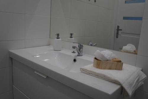een witte badkamer met een wastafel en een spiegel bij Apartament Gliwice Centrum Witkiewicza II in Gliwice