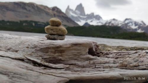 a stack of rocks sitting on top of a log at Hostel El Paredon in El Chalten