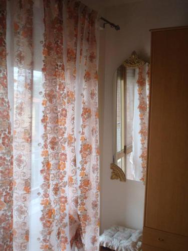 a room with a window with a curtain and a mirror at B&B da Debora in Pisa