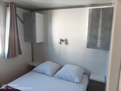 1 cama en una habitación con 2 almohadas en Mobile-Home en Argelès-sur-Mer